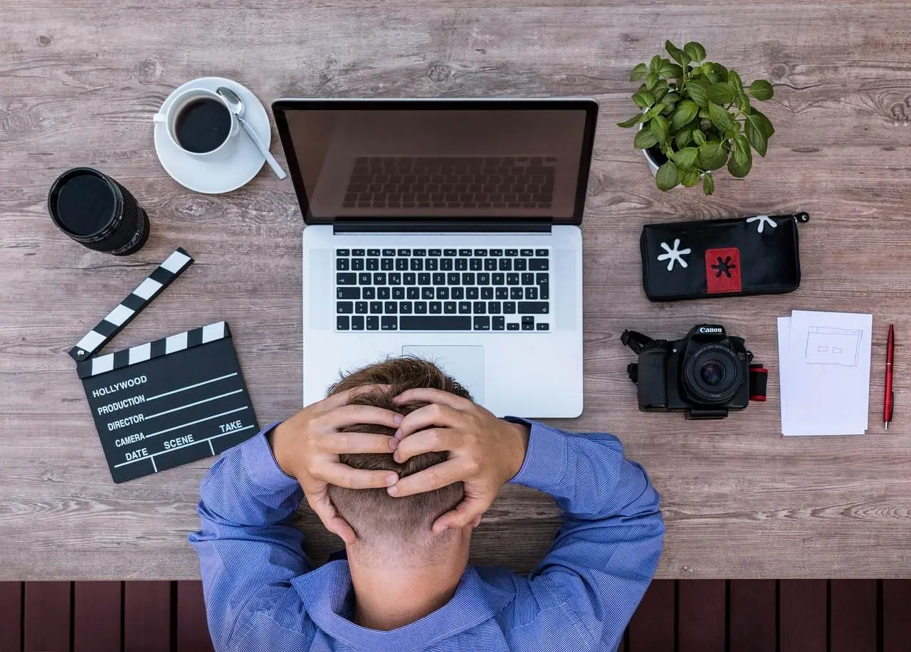 Is Poaching Employees Illegal? A stressed Employee on his table with his laptop.