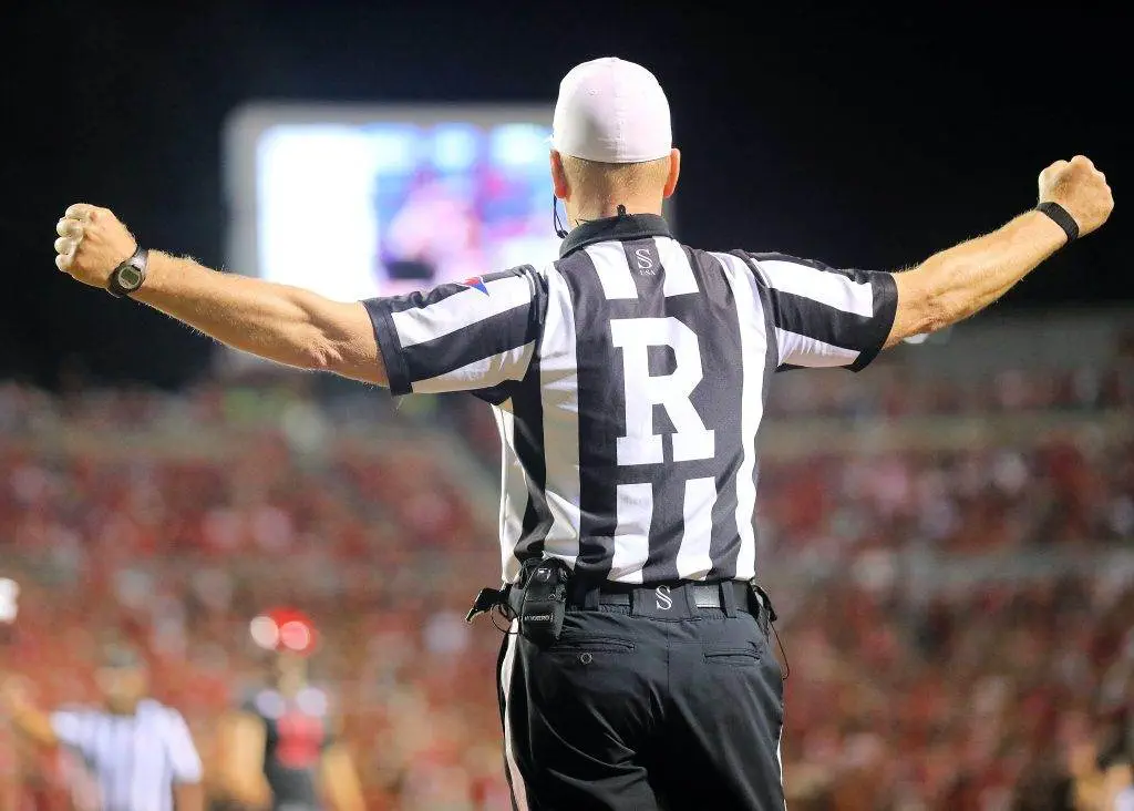 What Does the Yellow Card Mean in Soccer? a referee in a black and white striped uniform