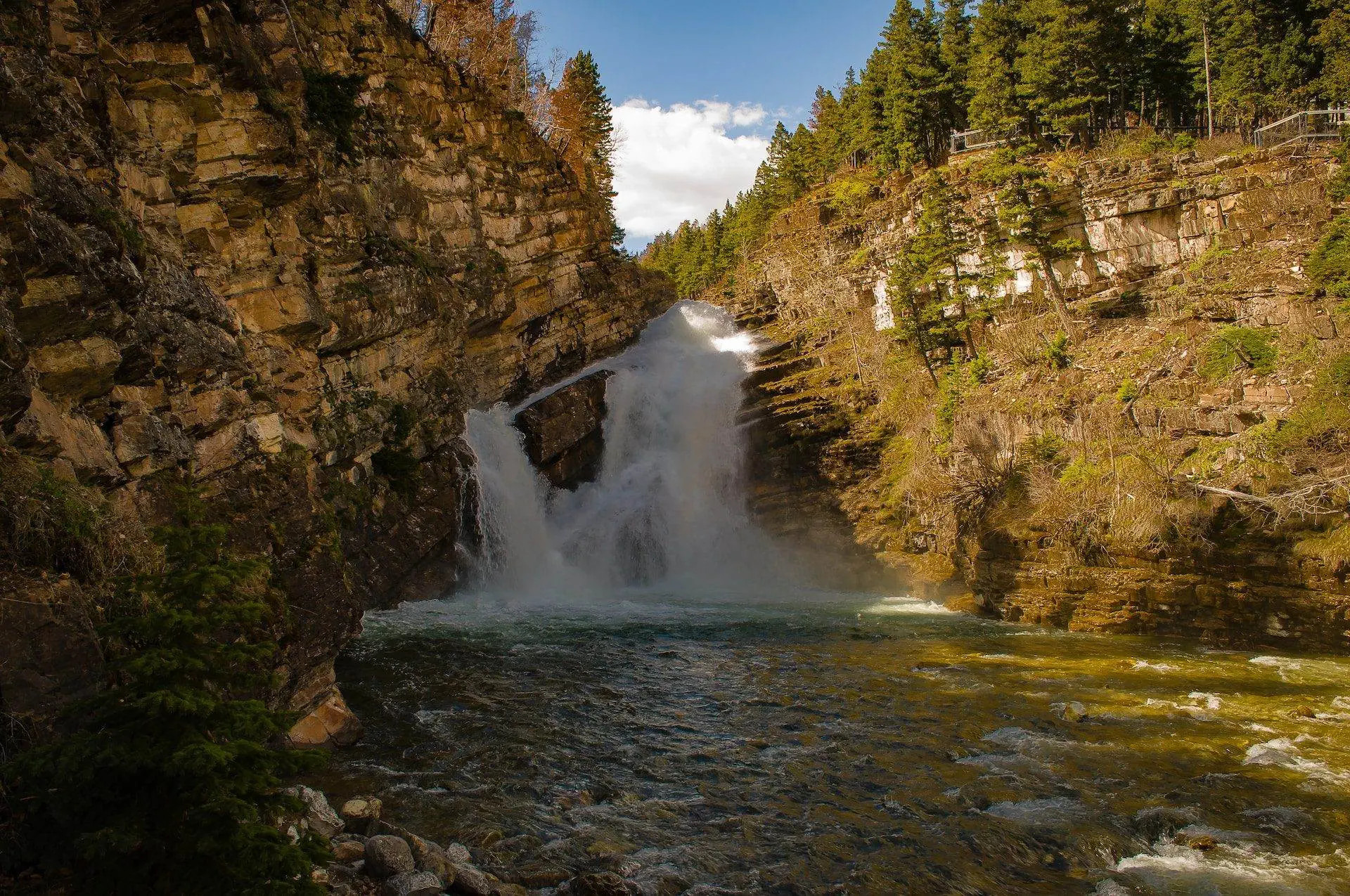 Waterton National Park- A Detailed Guide in 6 Main Points A scenic view of Cameron waterfall with brown rocks around. Cameron Falls is an iconic attraction of the Waterton National Park. It is known for its colours.