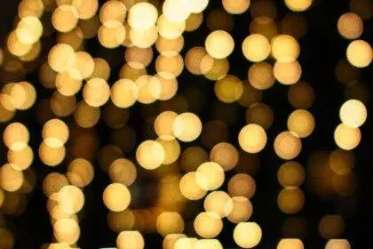 A close-up of golden twinkling lights representing Candlelight: 100 Years of Warner Bros.