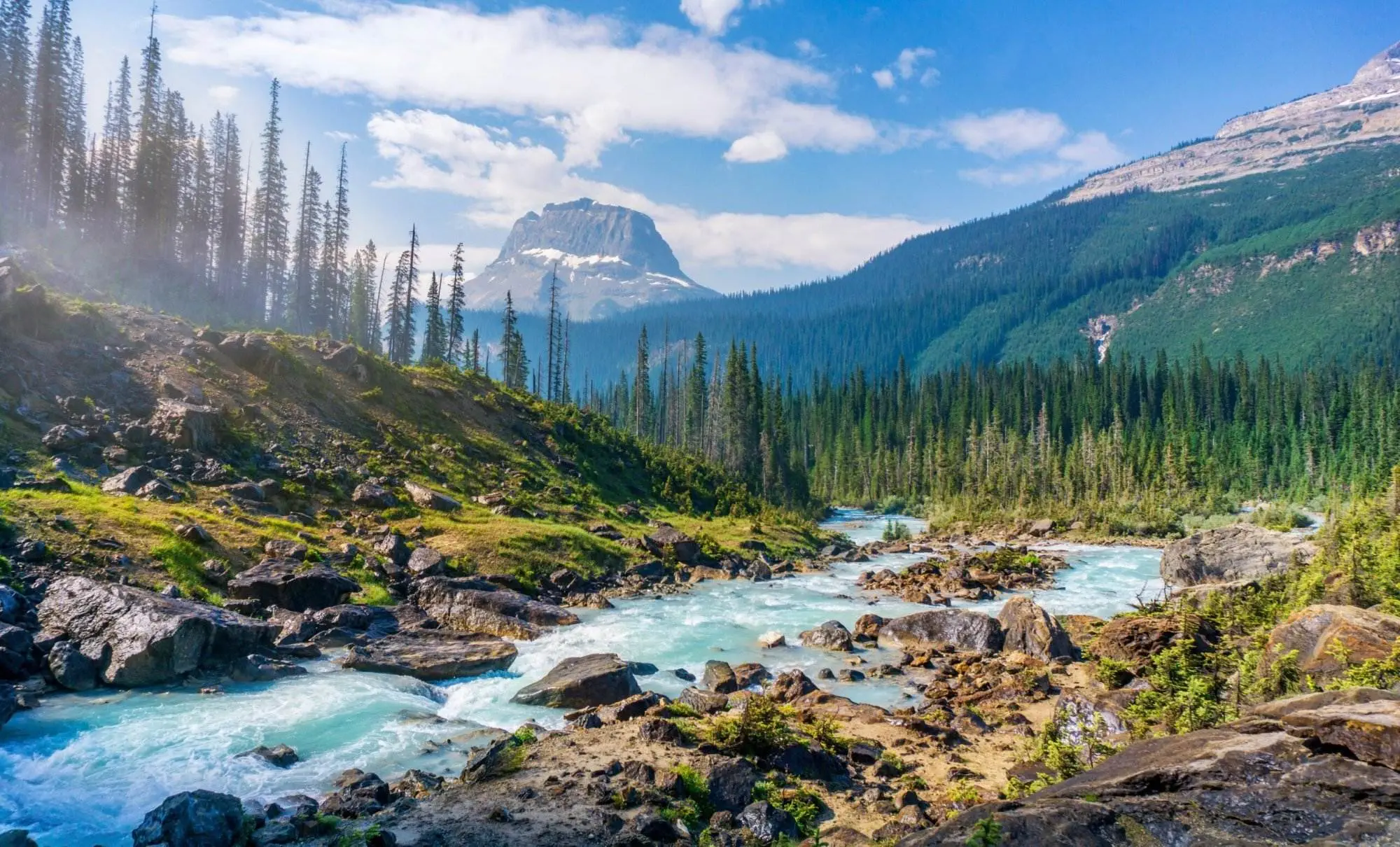 What Is Canada Known For: The 10 Compelling Facts Natural beauty is what is Canada known for. The scenic view of natural mountains, grass, trees and a river flowing in the middle.