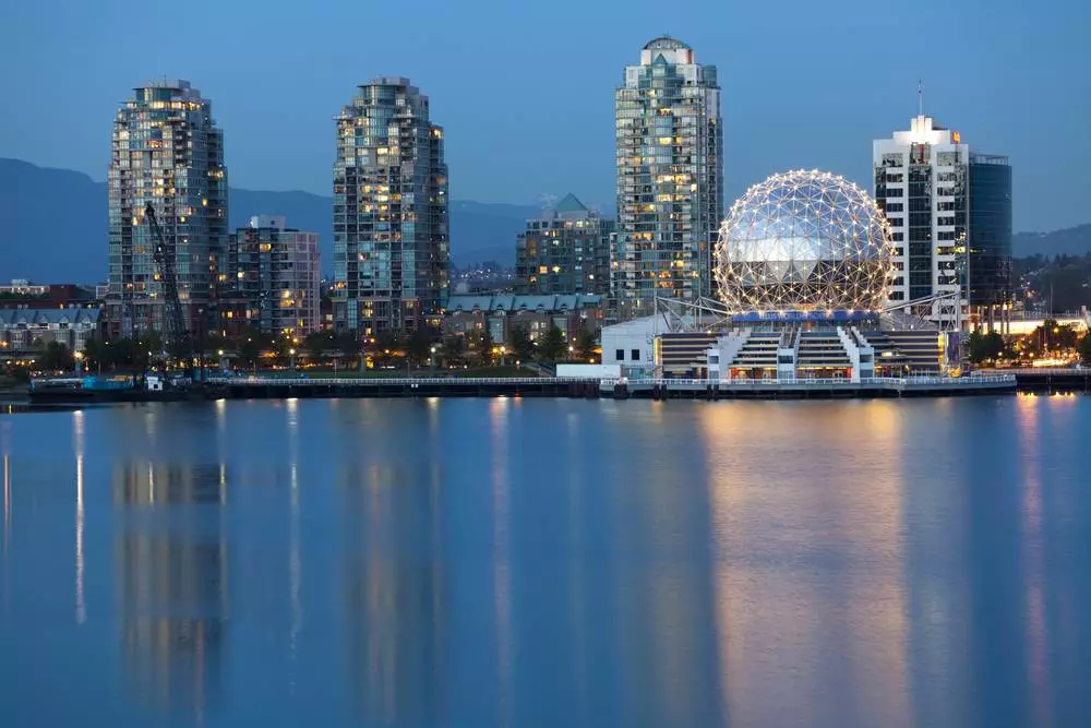 A scenic view of a waterbody beside the Science World in Vancouver during the evening time.