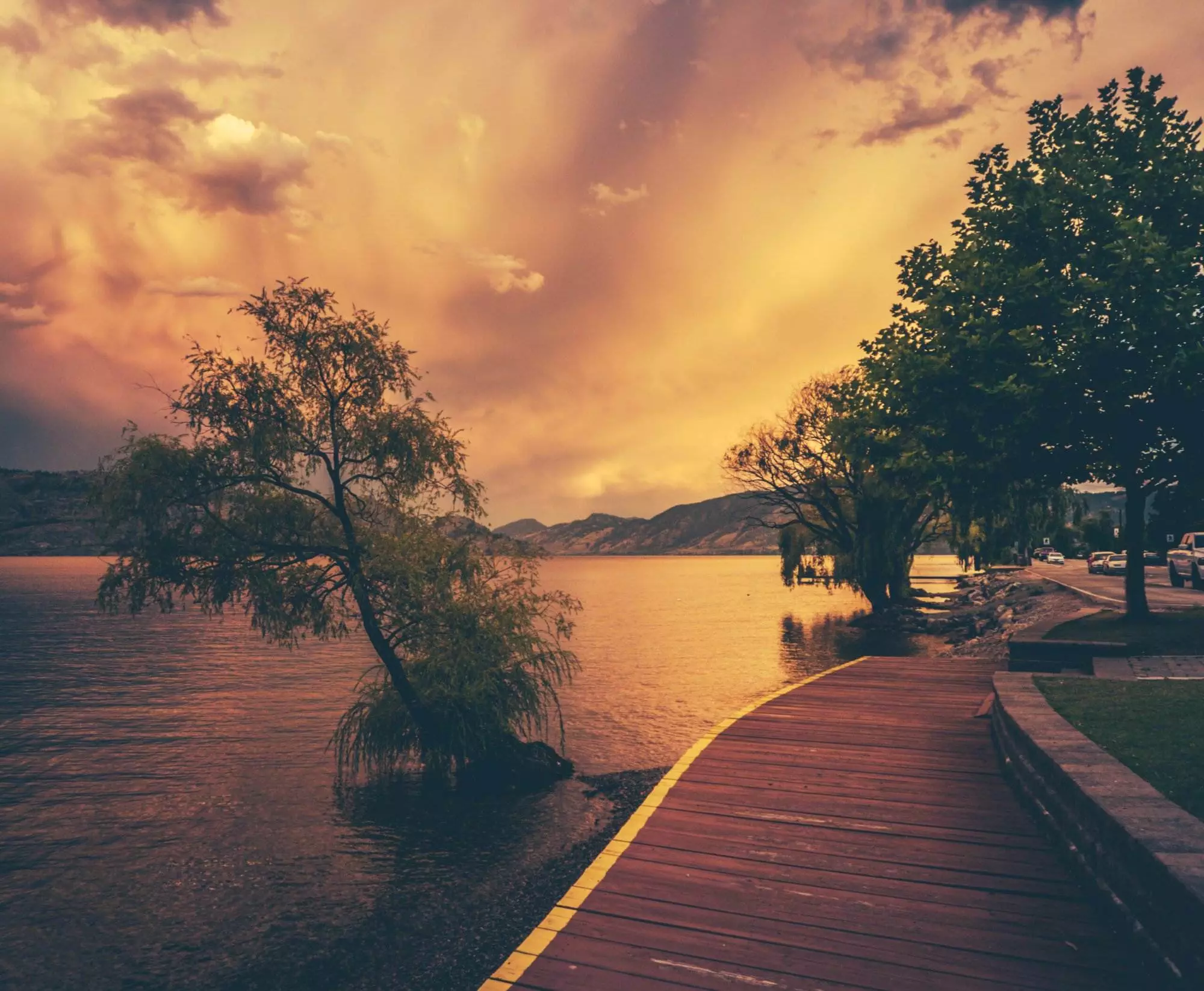The Beautiful Okanagan Lake with a wooden trail alongside Peachland at sunset.