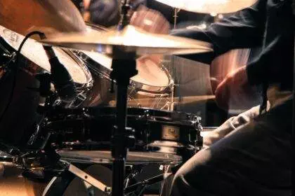 A close-up of a drum set while a man playing for a concert.