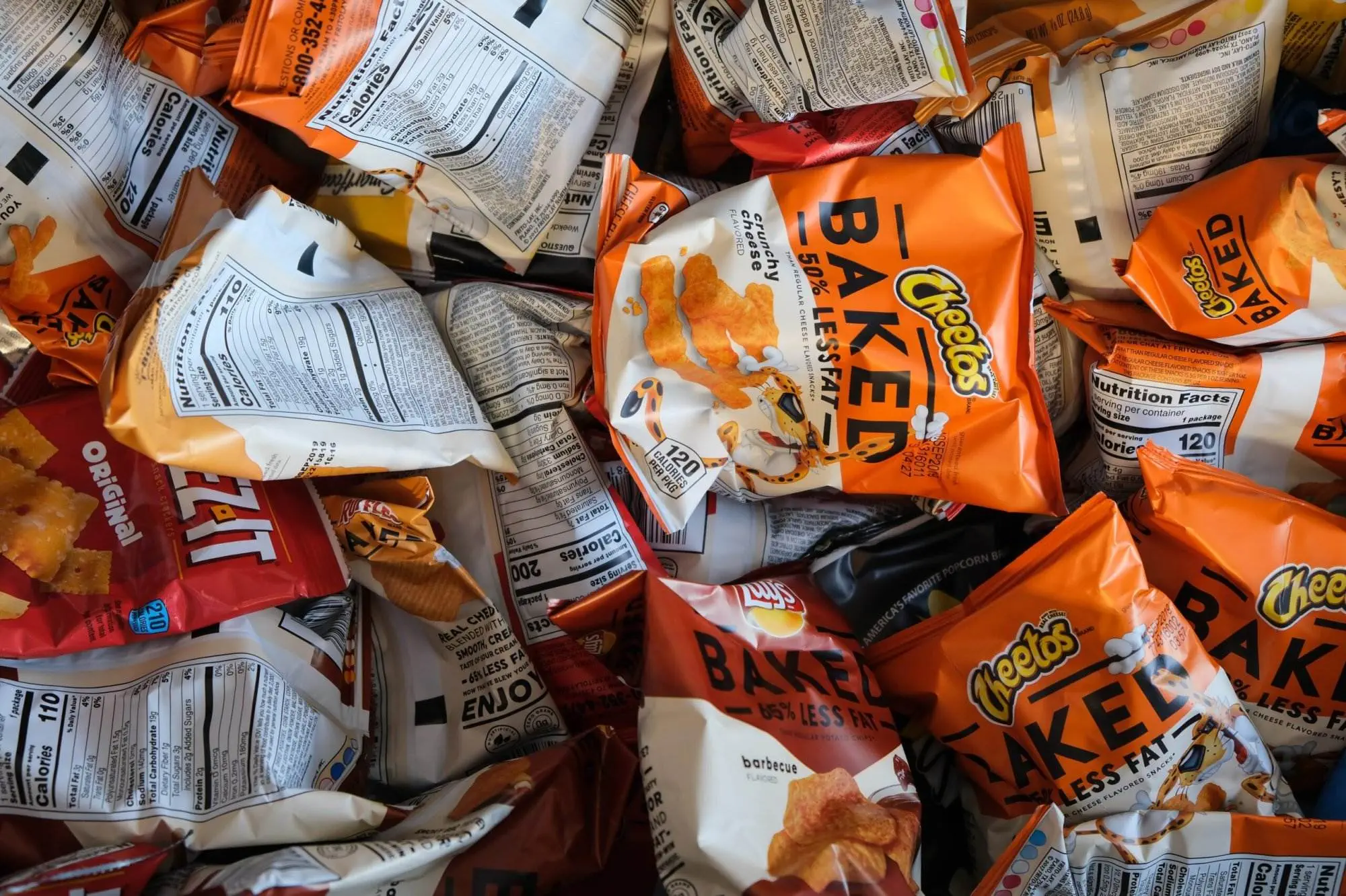 Importance of Health Education- Highlighted in 10 points A many orange-colored packets of junk snacks.