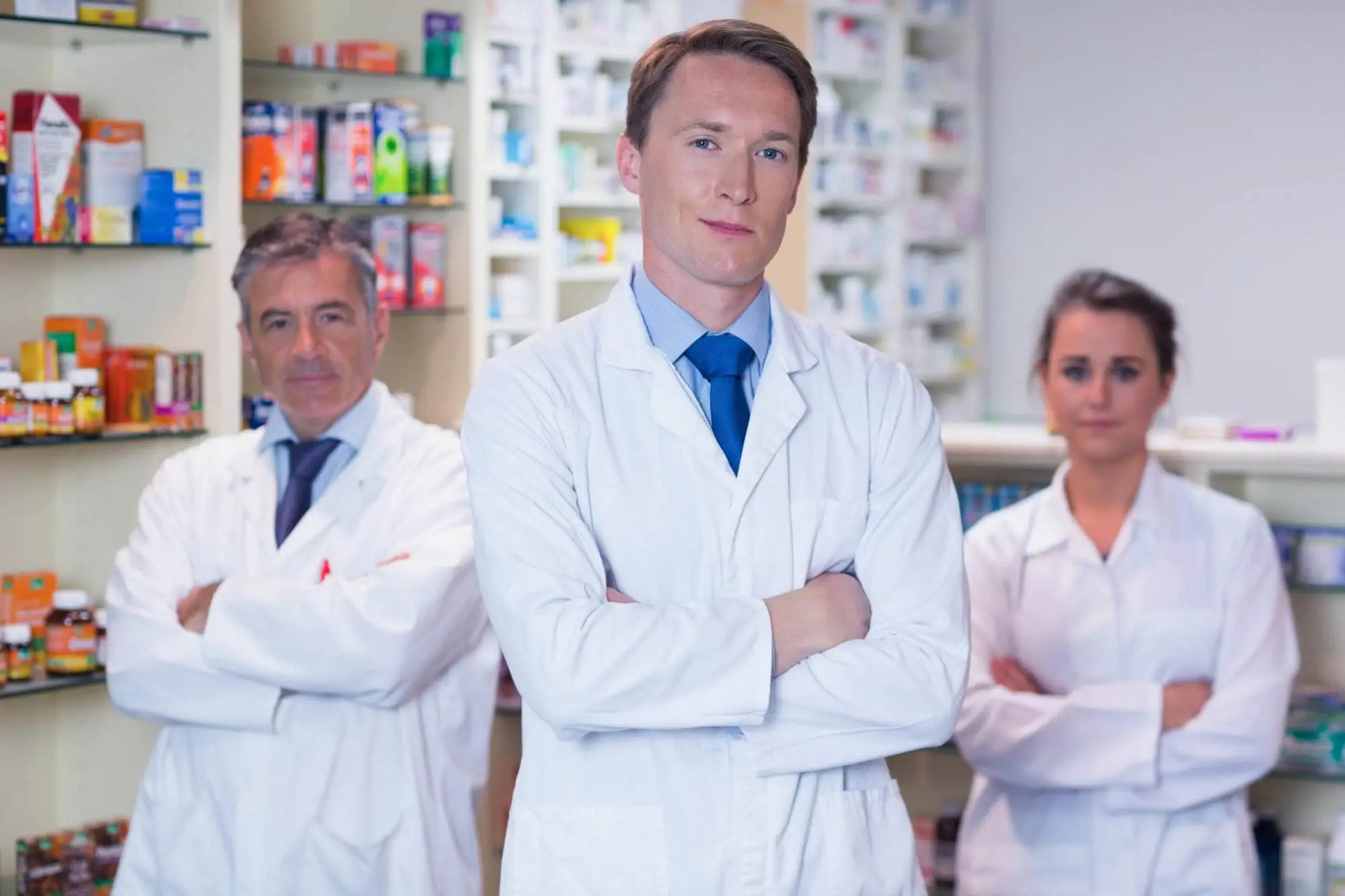 Is Pharmacy School Hard? A 3-Step Guide to Figure Out Facts Smiling pharmacy team standing with arms folded in the pharmacy