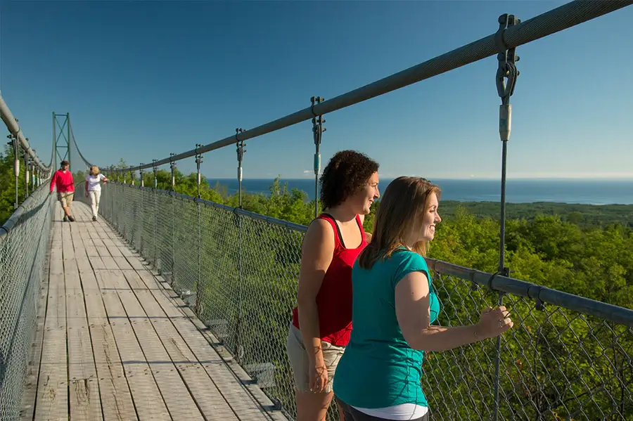 Everything You Can Do at the Blue Mountains Scenic Caves? People walk and enjoy the views from a bridge in the Blue Mountains Scenic Caves.