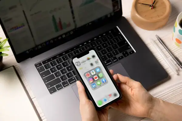 What are the Different Types of Advertising Mediums? A person holding the phone with Social Media apps.