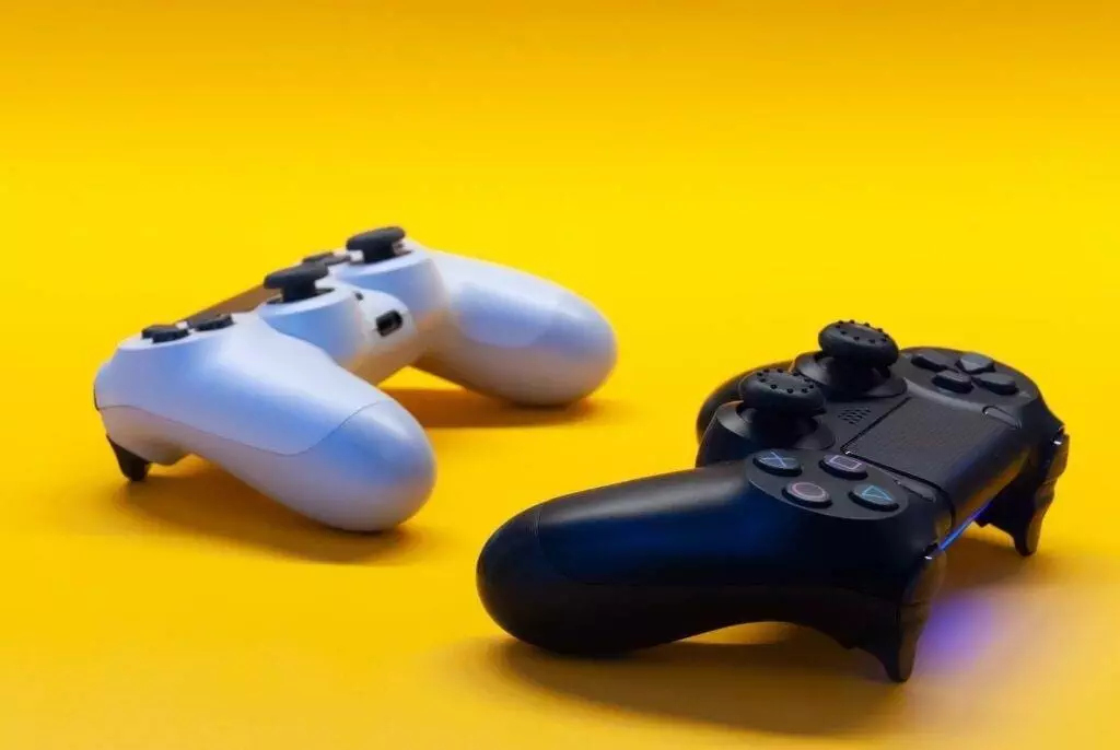 Two game controllers on a plain yellow background.