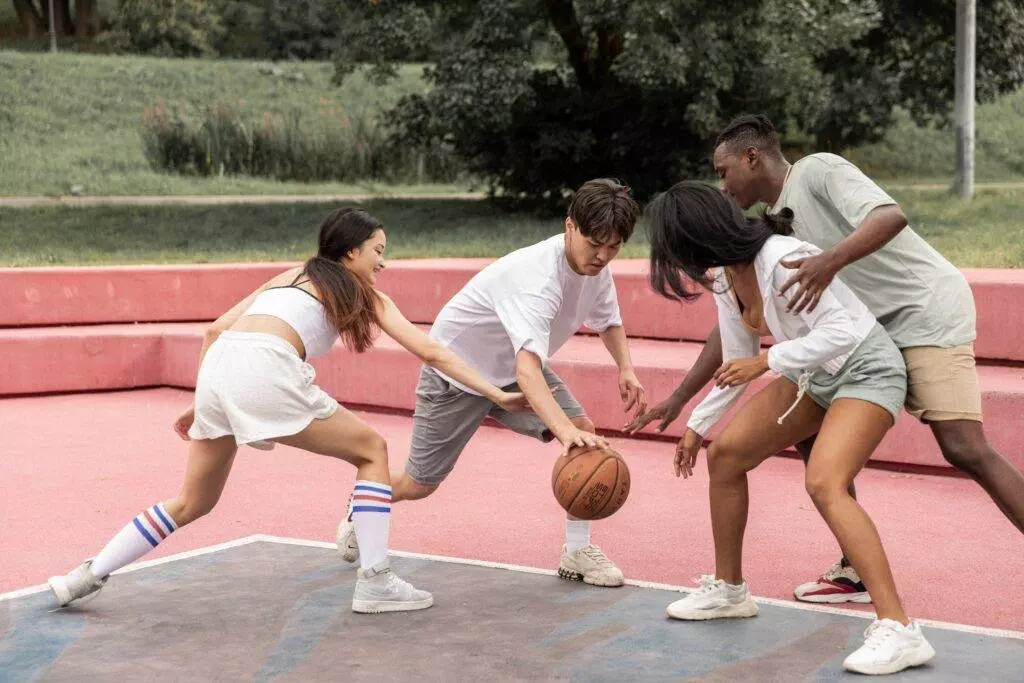 A group of people playing basketball on the ground.