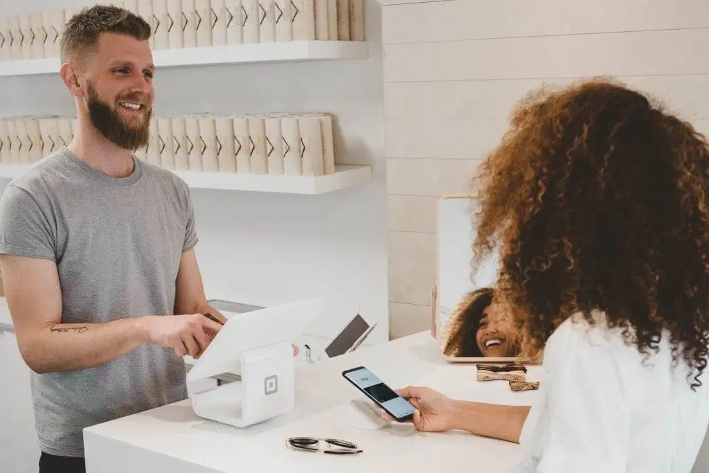 Who Is an External Customer? The Full Picture man in grey crew-neck t-shirt smiling to woman on counter