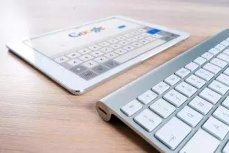 A keyboard and a screen with google page opened on it.